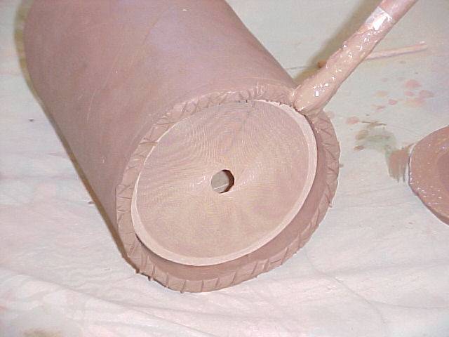 Applying slip to the bottom of the jug wall